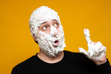 A crazy man covered in shaving foam shows a thumbs up. An idea, a thought.