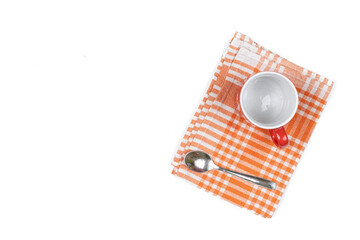 Top view of empty cup for coffee with spoon on the dishcloth with copy space above white background
