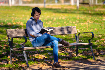 Man sitting in a park reading a book