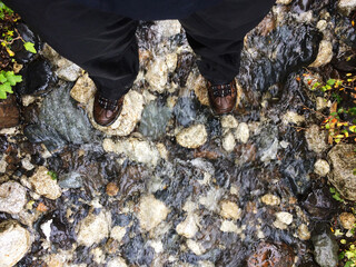 Eine Person steht in einem Flussbett und blickt nach unten. Patagonien, Nationalpark Torres del Paine.