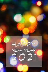 Happy New Year 2021 greeting card, blurred background of the twinkling lights of the Christmas tree. Greeting card background.