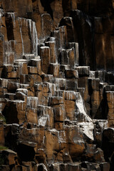 a waterfall formed by an interesting angular rocky cliffs, the white of which is about.birds