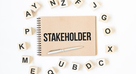 Text STAKEHOLDER on the craft colored notepad with block wood cubes on the white background