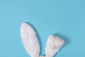 White Fluffy bunny ears isolated on pastel blue background. Creative easter concept
