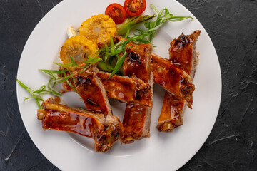 barbecue beef ribs with vegetable garnish on a white plate. Grilled ribs