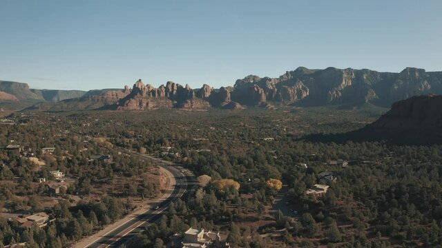 Aerial Drone View of residential areas and roads in Sedona and Oak Creek Canyon in Arizona on a bright and sunny fall day showing unique red rock formations and landscapes 