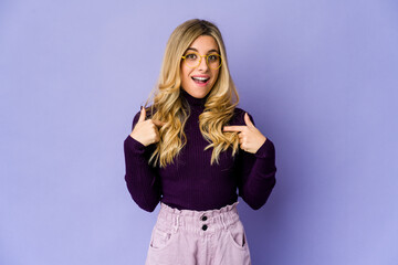 Fototapeta premium Young caucasian blonde woman surprised pointing with finger, smiling broadly.