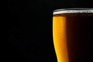 Glass of fresh beer isolated on a black background. Close-up
