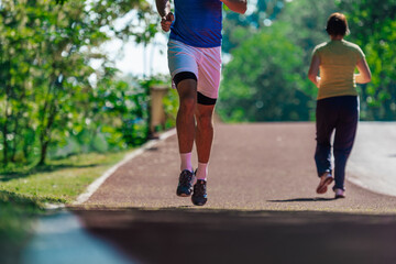 Close up feet with running shoes and strong athletic legs of sport man jogging on the running track
