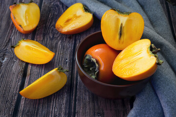 fresh organic ripe persimmons fruits on a wooden background.