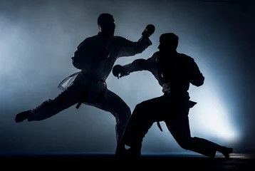 Fotobehang Kata training men isolated on dark background © qunica.com