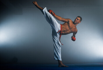 Young orange belt fighter training karate in gym