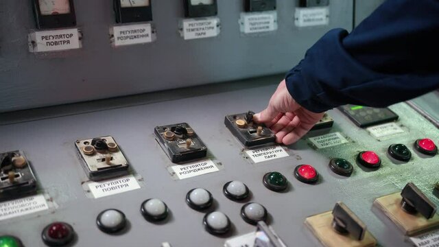 Close up. Engineer checking temperature pipes in control room. factory employee controlling, pressing important technology button at control panel of an automatic machine