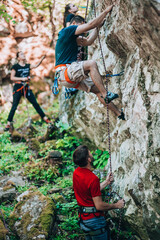 Fototapeta premium Male rock climbers climbing along a roof in a cliff