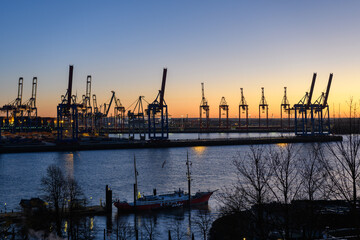 Fototapeta premium Hamburg, Germany: Shipyard cranes at the docks in the port in the twilight