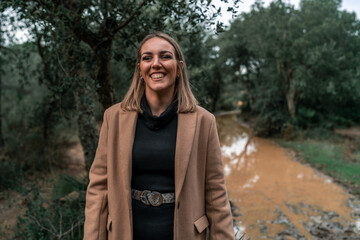 Chica rubia feliz en un bosque de otoño invierno al sur de españa vestida a la moda llamativa...