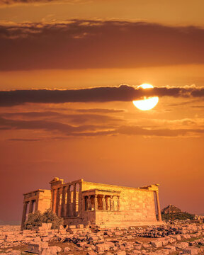 Erechtheion ancient temple with Caryatids statues on Acropolis illuminated by dramatic, fiery sunny sky, Athens Greece