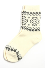 A pair of warm woolen winter socks with knitted white decorations, hearts isolated on white background. Socks for Christmas, holiday time or cold winter. White and grey color