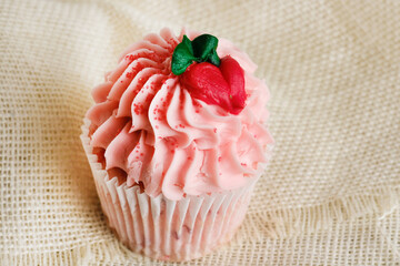 Strawberry cupcake with decorative pink icing for Valentine baked good sweet food.