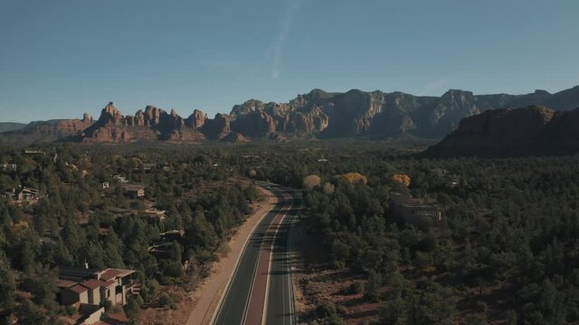 Aerial Drone View of residential areas and roads in Sedona and Oak Creek Canyon in Arizona on a bright and sunny fall day showing unique red rock formations and landscapes 
