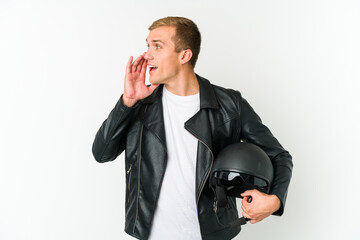 Fototapeta premium Young caucasian man holding a motorbike helmet isolated on white background