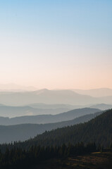 Carpathian mountains. Sunbeams thru forest. Mountain silhoettes. Ridgeline