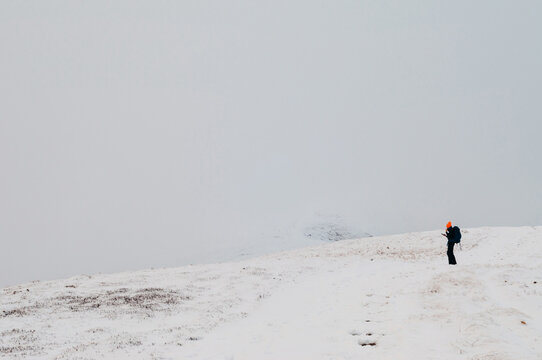 Winter adventure in mountains. Lonely traveller trying to fing path using  GPS maps. Winter in Carpathian mountains