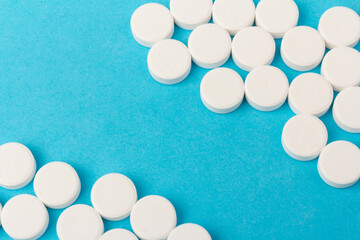 Heap of pills on blue background. Medicine, pharmacy and health concept.