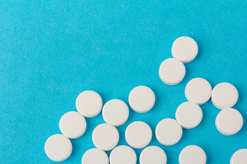Heap of pills on blue background. Medicine, pharmacy and health concept.