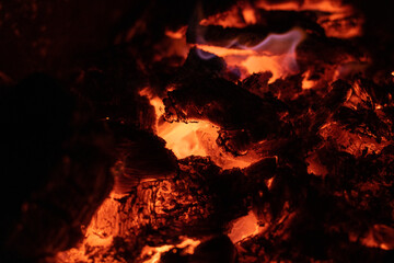 embers, fire, flames and burnt wood of bonfire, concept of burn and relaxation