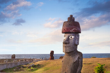 Moai heads near the Ahu Tahai Ceremonial complex on Easter Island, against a colorful sky.