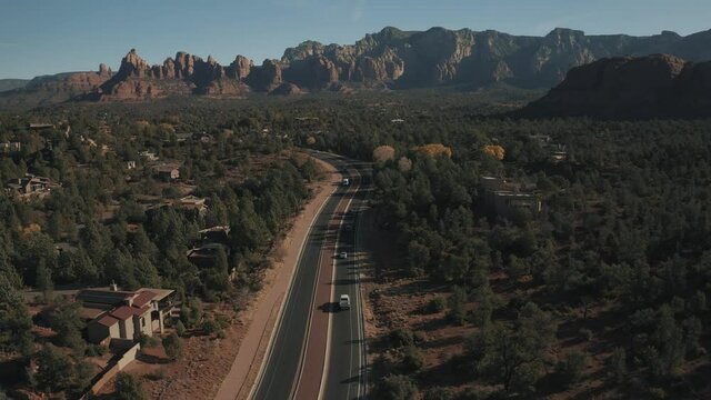 Aerial Drone View of residential areas and roads in Sedona and Oak Creek Canyon in Arizona on a bright and sunny fall day showing unique red rock formations and landscapes 