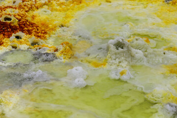 yellow and red stones in a volcanic crater that heat and boil from the heat