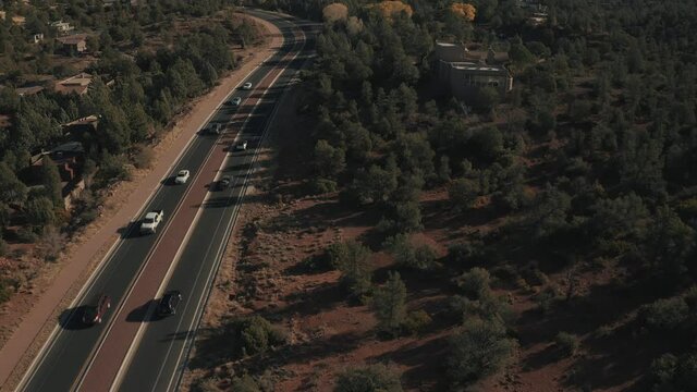 Aerial Drone View of residential areas and roads in Sedona and Oak Creek Canyon in Arizona on a bright and sunny fall day showing unique red rock formations and landscapes 