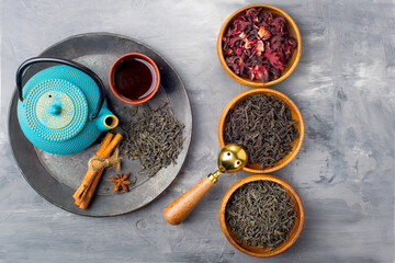 three types of tea in wooden cups on a gray background