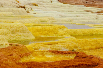 yellow and red stones in a volcanic crater that heat and boil from the heat