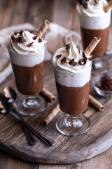 Chocolate mousse dessert parfaits on a wooden board ready for serving.