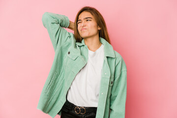 Young skinny caucasian teenager girl having a neck pain due to stress, massaging and touching it with hand.