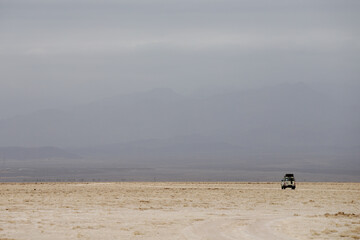 Fototapeta na wymiar in the desert salt lake where in the distance you can see a jeep