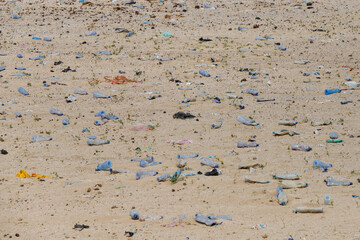 in the desert tossed in the sand a lot of plastic bottles and other waste