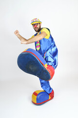 The clown is a man in a bright blue and yellow suit, glasses and a hat, playing emotionally.