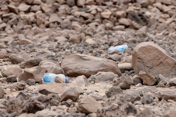 in the desert tossed in the sand a lot of plastic bottles and other waste
