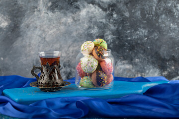 Colorful sweet doughnuts with a cup of tea