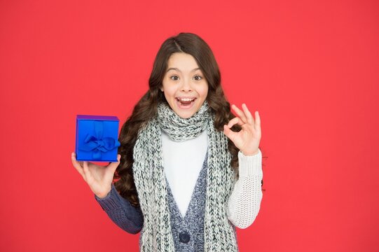 stylish child girl in casual warm apparel with box after successful seasonal shopping on xmas holidays, consummation of sale