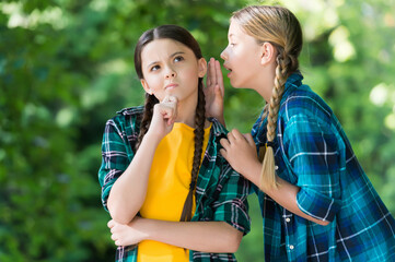 Everybody knows that. Chattering girls summer outdoors. Little child whisper news in friends ear. Top secret. Hearing all chit-chat and gossip. Gossiping and talking. Communication between friends