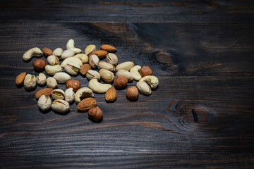 Mix of nuts on a wooden background. Hazelnuts, cashews, pistachios and almonds