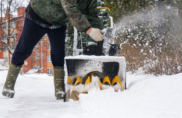 Man clearing snow with snow plow, close-up, snowfall concept