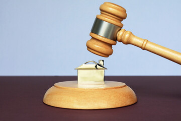 Auctioneers gavel over a house keyring. Property auction concept.