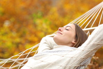 Relaxed woman resting on hammock in fall season