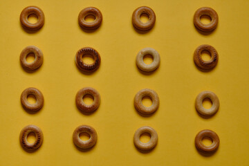 Top view of Sushki pattern on yellow surface. dish of Russian and Ukrainian cuisine, solid ring-shaped product made of dough, type of mutton products. One of the most common tea snacks among Slavs